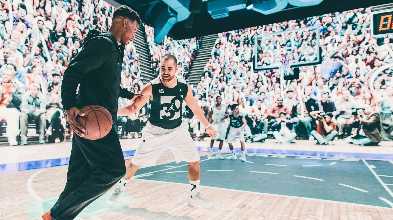 A player drives past a defender in a 30th-anniversary Jordan jersey on the LED court