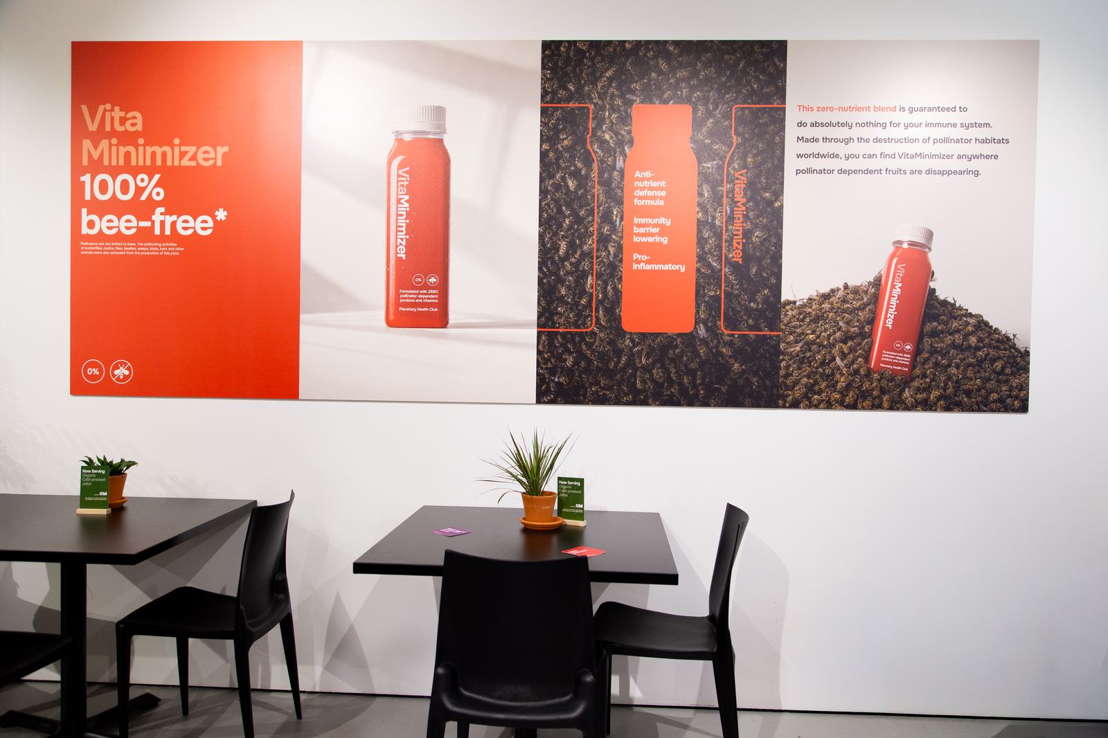 VitaMinimizer poster wall reading 100% bee-free above the juice bar tables